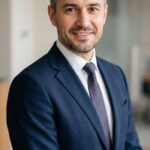 Портрет уверенного бизнесмена компании Нео Магнитс на нейтральном фоне в студийном освещении
